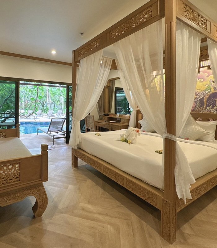 Deluxe Pool Access room with carved teak four-poster bed