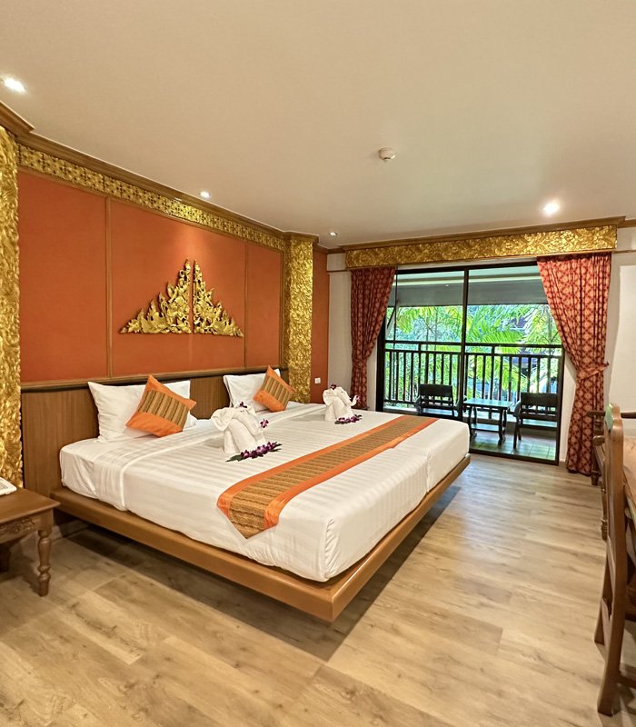 Deluxe room with terracotta walls and gold Thai motif